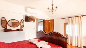 A bedroom with a red quilted bedspread, a wooden headboard, a mirror, and a chandelier. - Venetian Elegance Villa - near Venice historic center (Mira)