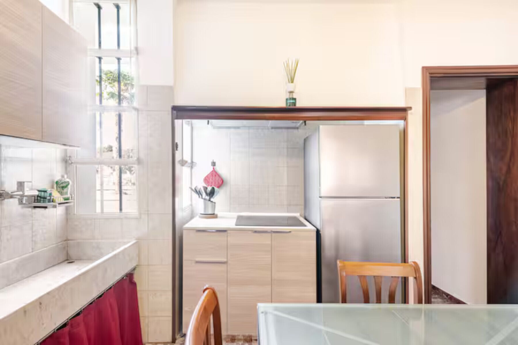 Een moderne keuken met een koelkast, een spoelbak en een eethoek met een tafel en stoelen.