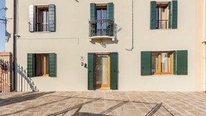A building with a central entrance, multiple windows with shutters, and a balcony with a railing. - Venetian Elegance Villa - near Venice historic center (Mira)