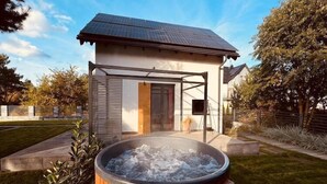 A modern house with a solar panel roof, a hot tub, and a well-maintained garden. - Holiday home with jacuzzi, for 4 people (Rozewie)