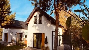 A modern two-story house with a white exterior, a sloped roof, and a visible garage door. - Holiday home with jacuzzi, for 4 people (Rozewie)
