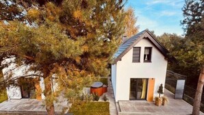 Una casa moderna con techo inclinado, puerta principal y un pequeño porche.