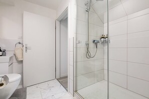 Deluxe appartement, uitzicht op bergen | Badkamer | Een douche, een haardroger, handdoeken, zeep