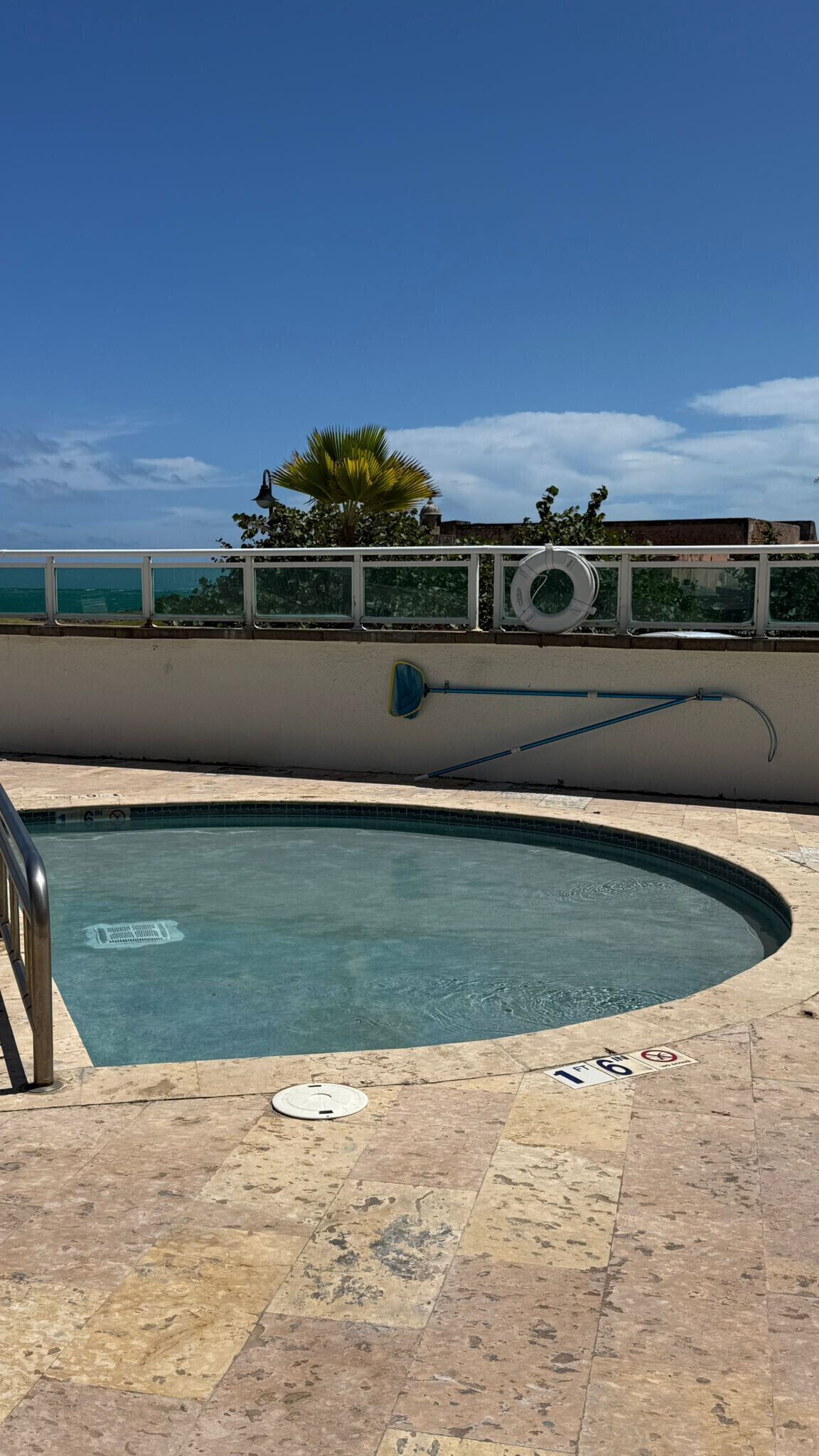 A swimming pool with a tiled deck, a lifebuoy, and a pool heater.