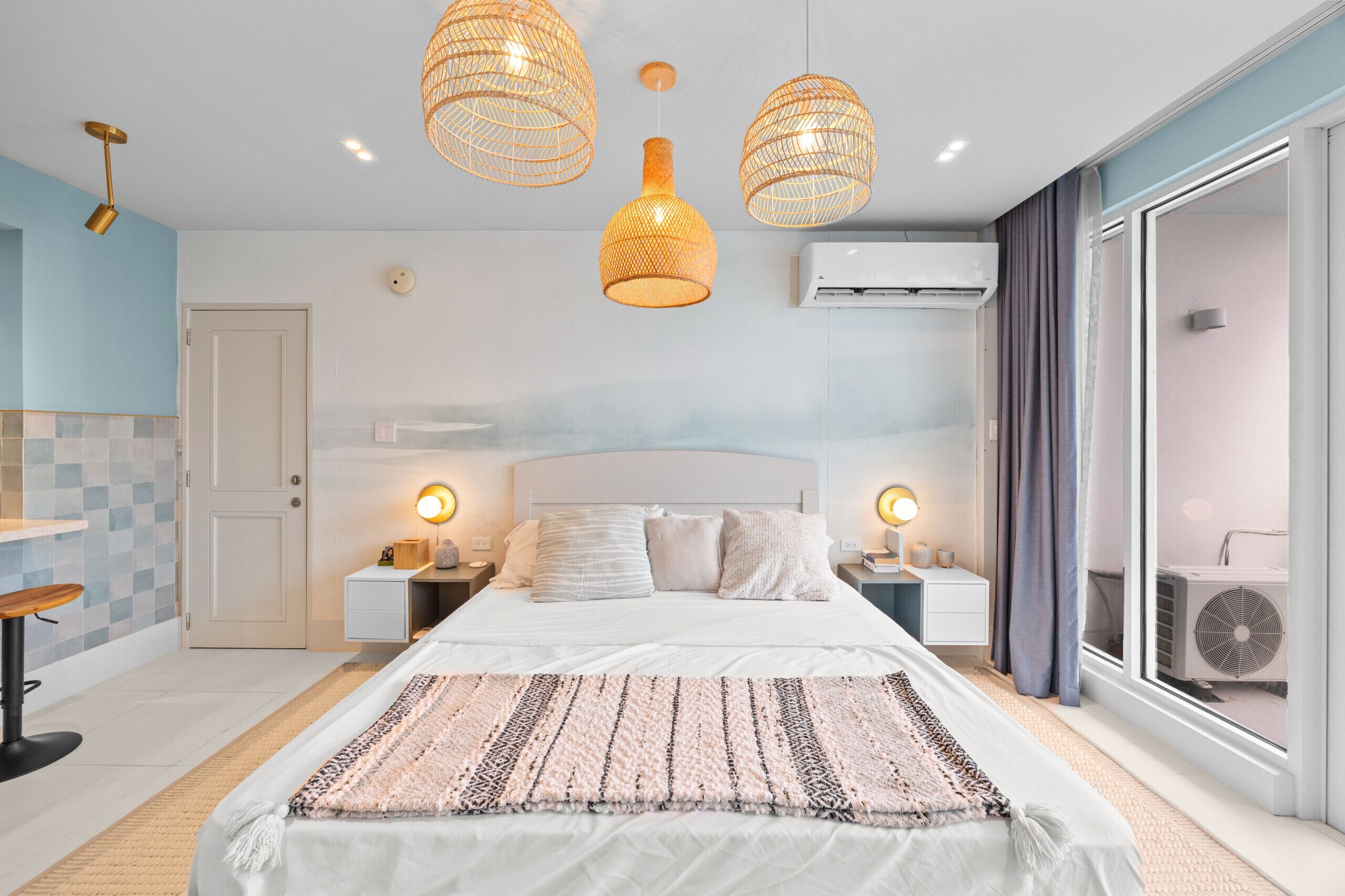 Une chambre moderne avec un grand lit, deux lampes de chevet et une grande fenêtre avec des rideaux.