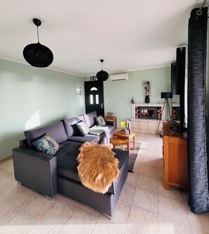 A living room with a sofa, a coffee table, and a television. - Villa Anley - Enjoy amazing sea views between tradition and modernity! (Ratzaklion)