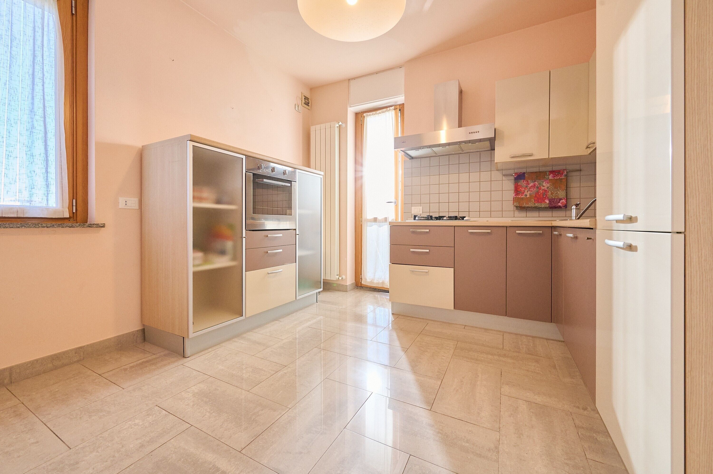 A kitchen with a refrigerator, oven, and tiled backsplash.