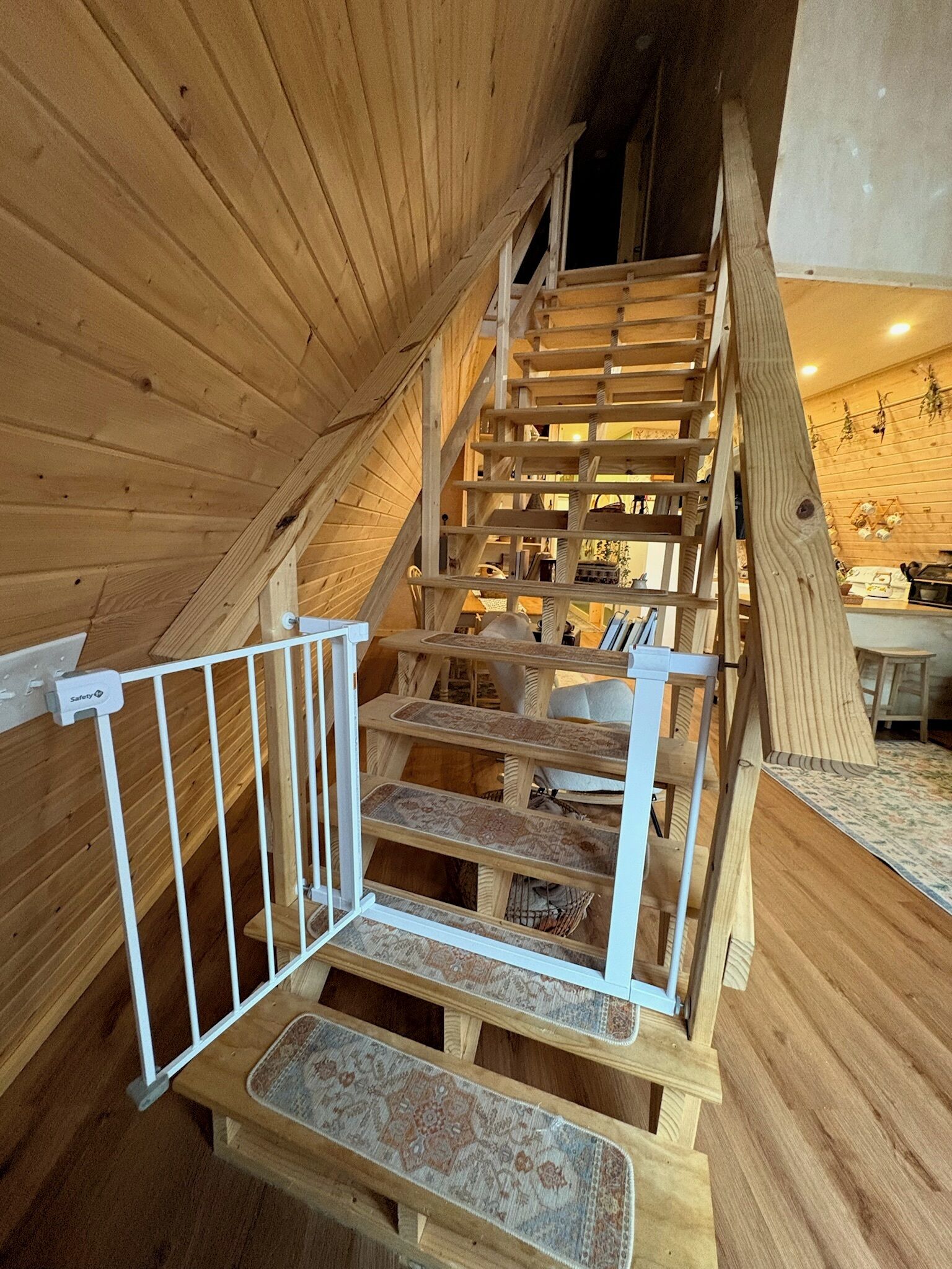 A wooden staircase with a railing, leading to an upper floor.