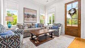 A living room with a wooden coffee table, patterned sofas, and a large painting. - New Luxurious & Elite! Steps to Auburn University & Downtown (Auburn)