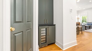 Una cocina con armarios oscuros, un refrigerador y piso de madera.