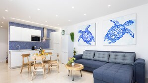 Un salon moderne avec un canapé et un coin repas comprenant des chaises et une table.