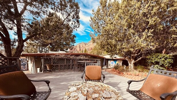 An outdoor seating area with a round table made of wood and metal chairs. - Coffee Pot Trailhead Bungalow, Red Rock Views, Private Patios, Red Rock Pass (Sedona)