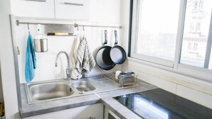 Eine Küche mit zwei Spülen, einem Fenster und einem Geschirrgestell.