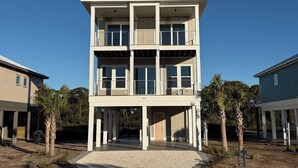 A two-story building with a balcony on the upper floor, a covered entrance, and a number '2240' on the facade. - New Construction, Beach Views, Private Pool, Pet-Friendly, SGI Plantation (St. George Island)
