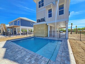 A modern two-story house with a swimming pool, a covered patio, and a fenced backyard. - New Construction, Beach Views, Private Pool, Pet-Friendly, SGI Plantation (St. George Island)