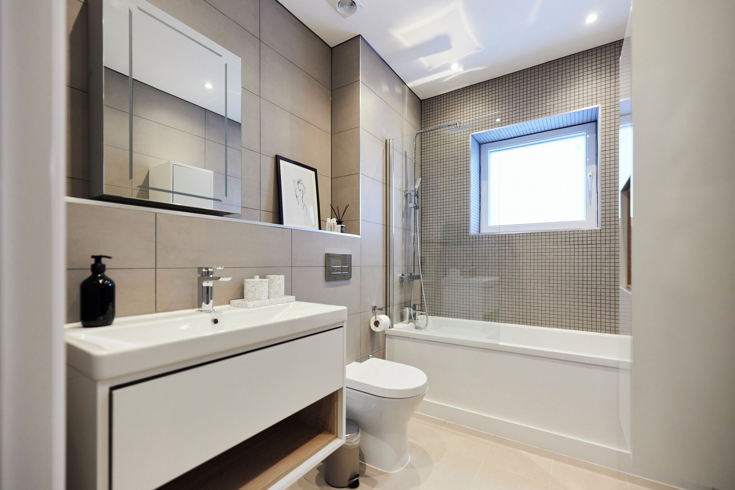 Ein modernes Badezimmer mit Toilette, Waschbecken und Badewanne.