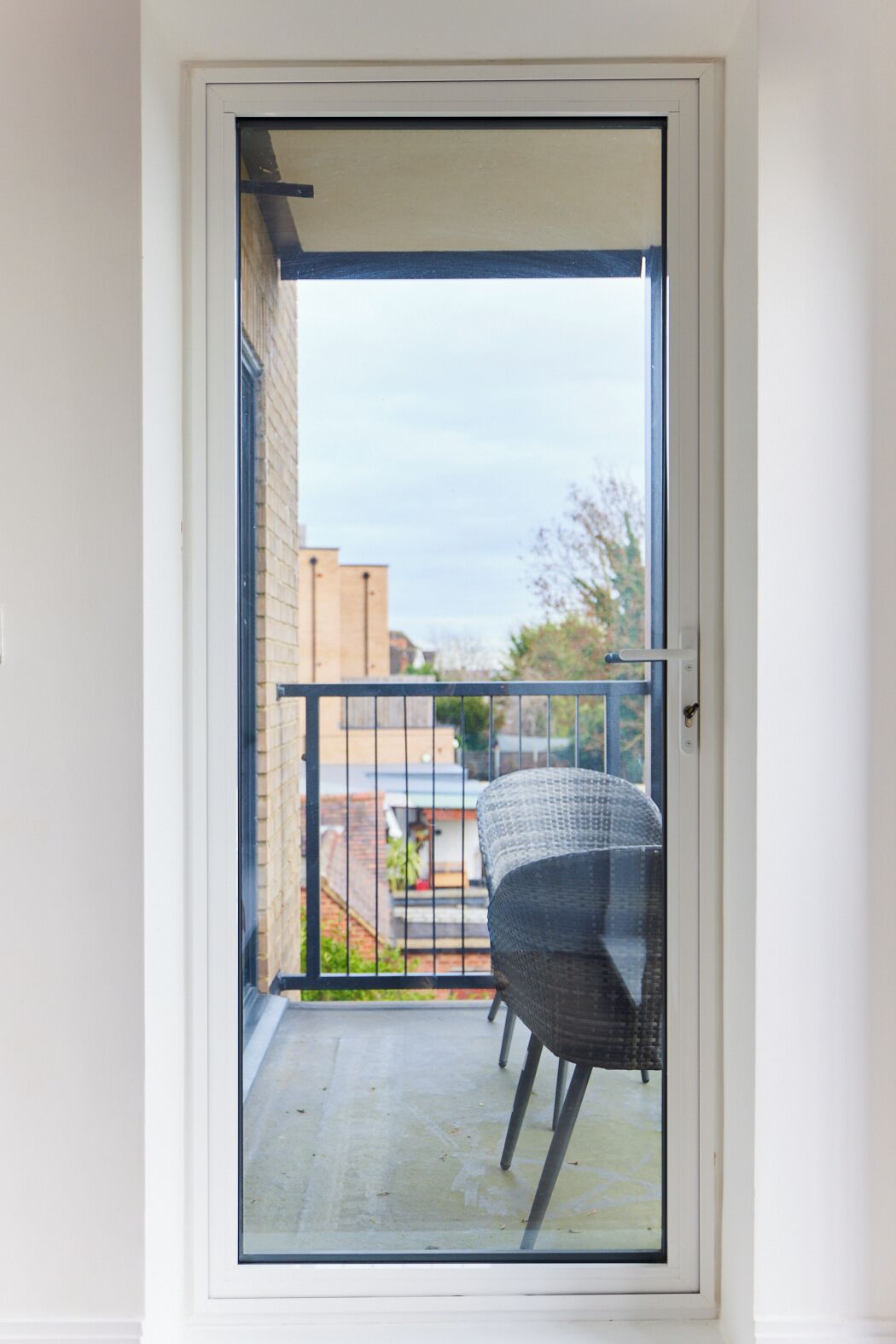 A balcony with a chair and a metal railing.