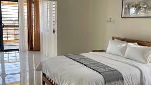 A bedroom with a bed, a ceiling fan, and a window with curtains.