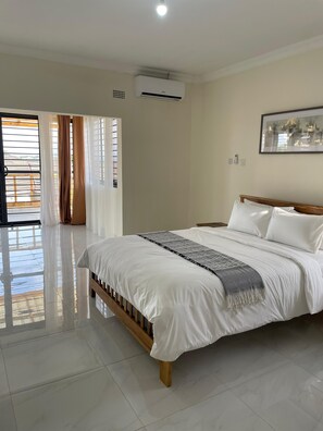 Un dormitorio con una cama, un ventilador de techo y una ventana con cortinas.