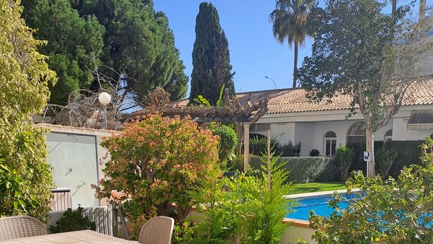 An outdoor patio with a table and chairs, a pool, and surrounding greenery. - ALBIR, apartment for 4 pers., ground floor with garden, 100m to the beach, super pool, air conditioning (L’Alfàs del Pi)