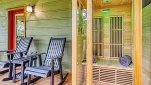 Una cabaña de madera con un porche y una sala de sauna.
