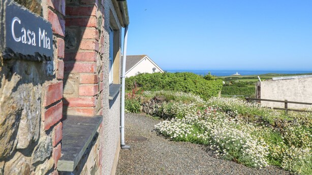 A building with a sign reading "Casa Mia" and a view of the sea. - Casa Mia (Goodwick)