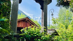 A wooden cabin with a mountain backdrop, surrounded by lush greenery. - Authentic Chalet in Chamonix-Mont-Blanc (Chamonix-Mont-Blanc)