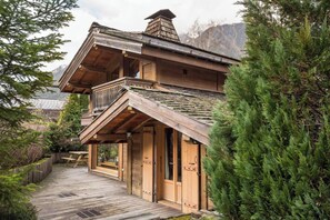 A wooden cabin with a balcony, a wooden deck, and a mountainous backdrop. - Authentic Chalet in Chamonix-Mont-Blanc (Chamonix-Mont-Blanc)