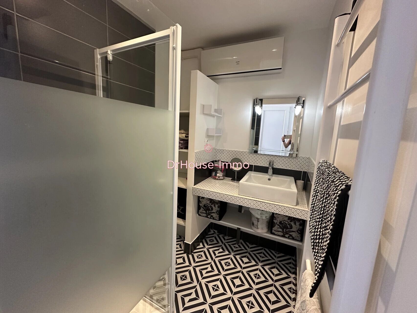 Un bany amb un lavabo blanc, un mirall i un terrapatró.