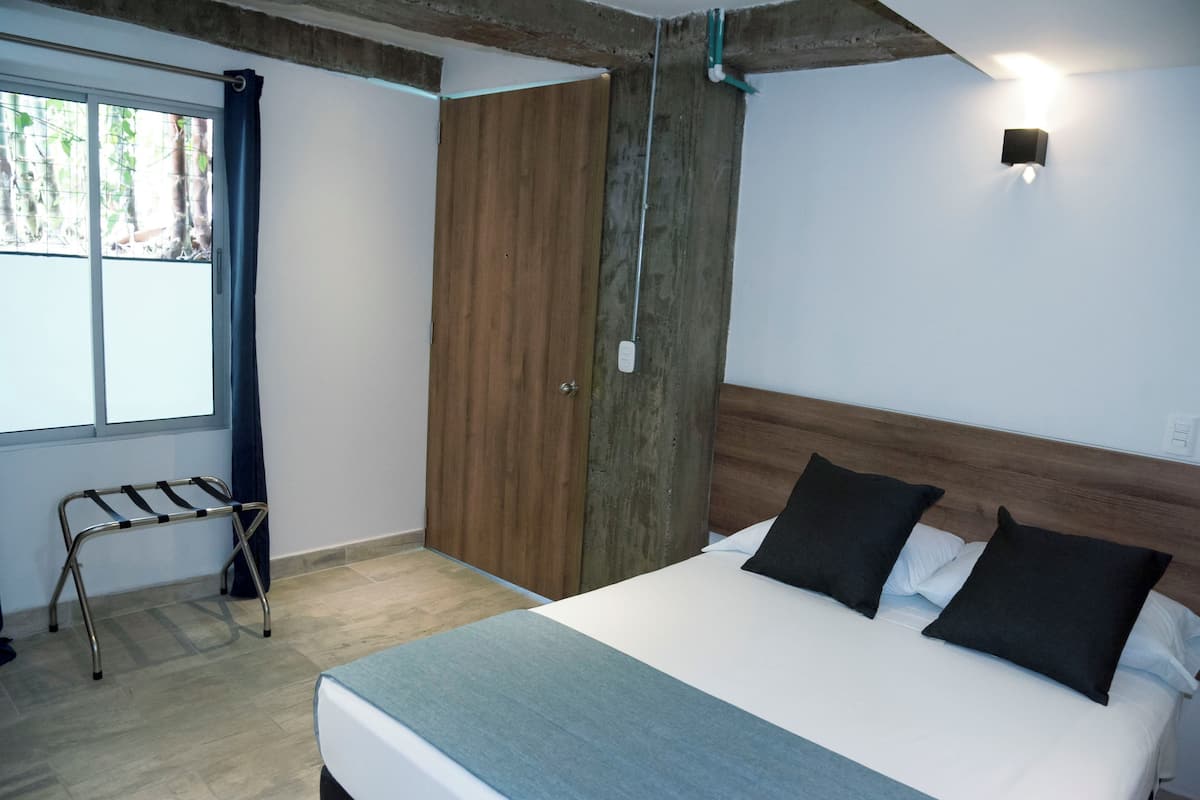 Un dormitorio con cama, armario de madera y ventana con cortinas.