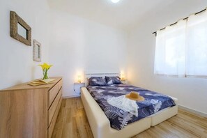 A bedroom with a bed, bedside lamps, a wooden dresser, and a window with curtains. - Heaven, WaCa Apulian villa (Puglia)