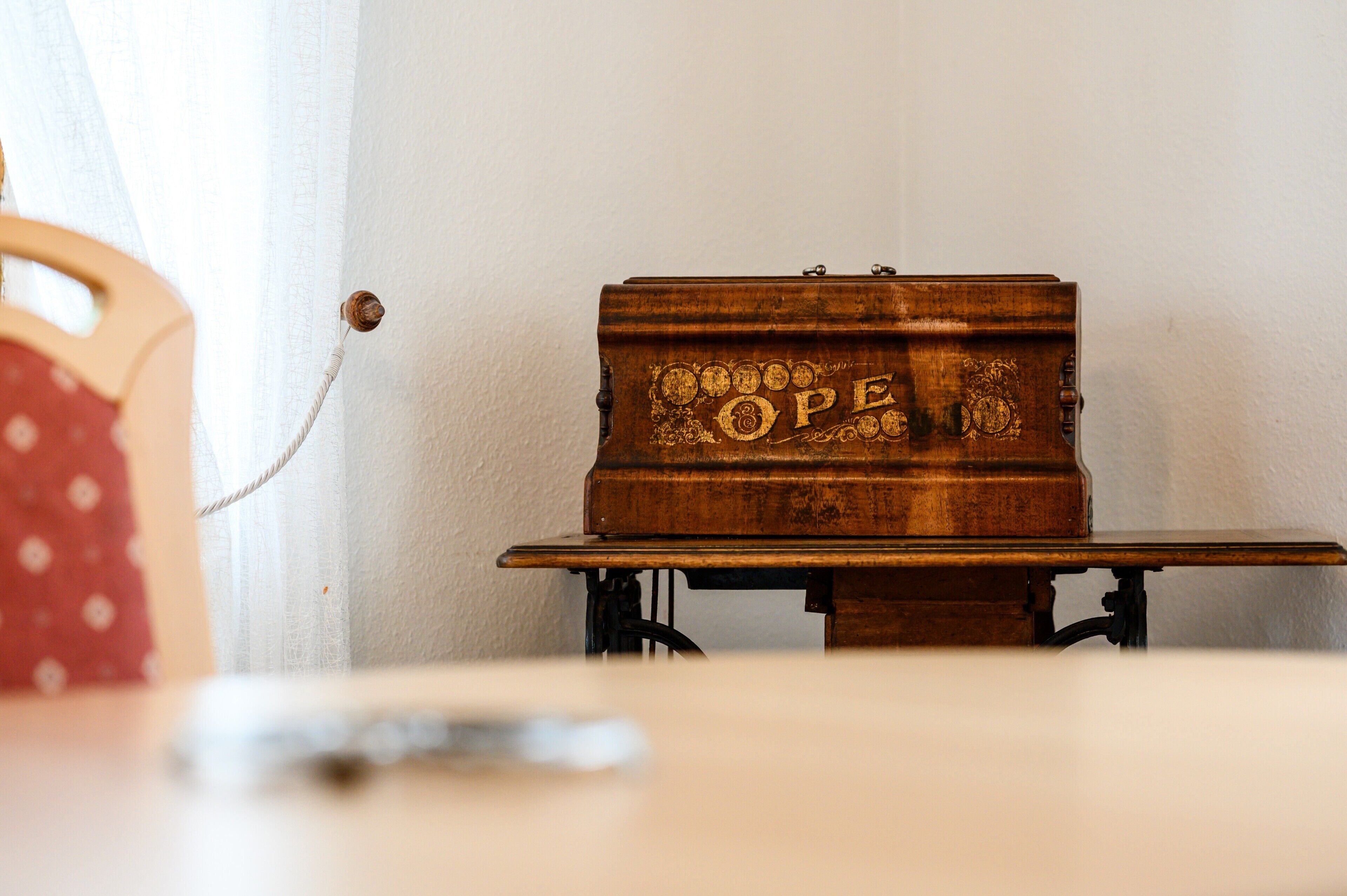 A wooden chest with the word 'OPEN' engraved on it, placed on a small table.