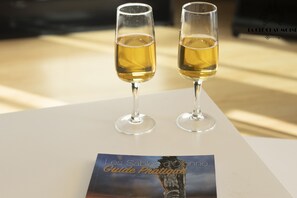 Two glasses of wine on a table with a brochure titled "Les Sables d'Olonne Guide Pratique" in front of them. - Escale Bleue - Balcon ensoleillé & Vue côte sauvage (Les Sables-d´Olonne)