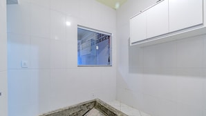 A bathroom with white tiled walls, a window, and a shower area. - Casa com Ar e Wi-fi pr Xima Praia da Tapera (Florianópolis)