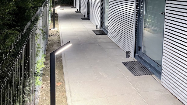 Moderni rakennus, jonka edessä on pitkä, suora kävelytie, joka johtaa portilla varustetulle sisäänkäynnille.