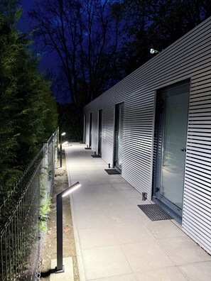 A modern building with a long, straight pathway leading to a gated entrance. - Student House Pawilony (Warsaw)