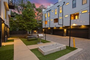 A modern building with a paved courtyard, outdoor seating, and a barbecue grill. - Great Location Near Gulch, 12 South & Broadway (Nashville)