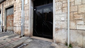 A stone building with a closed metal door and a garage door. - Room 2 - Anita Rooms Bari (Bari)
