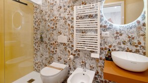 A bathroom with a toilet, bidet, and a sink with a mirror above it. - Room 3 - Anita Rooms Bari (Bari)