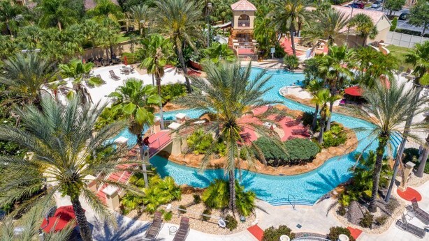 A resort with a central swimming pool surrounded by palm trees and lounge chairs. - Headline (Davenport)