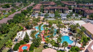 A resort with multiple buildings, a central swimming pool, and surrounding palm trees. - Headline (Davenport)