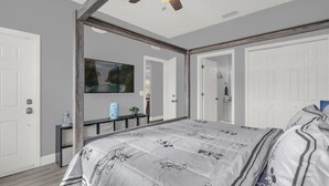 A bedroom with a large bed, a ceiling fan, and a mirror reflecting the room. - Headline (Davenport)
