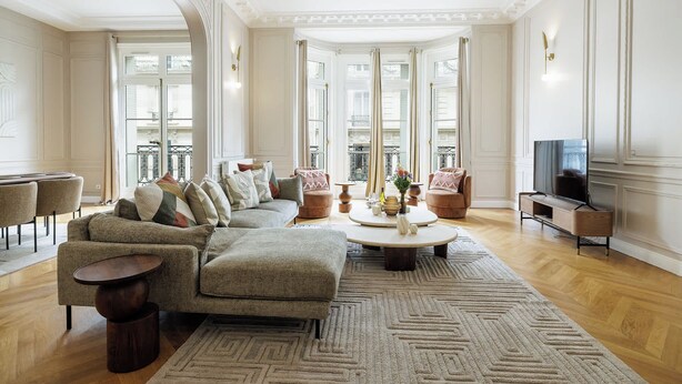 Ein geräumiges Wohnzimmer mit einer großen Couch, einem Couchtisch und einem Fernseher.