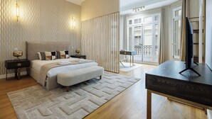 Ein Hotelzimmer mit Bett, Nachttischen, einem Schreibtisch und einem Fernseher.