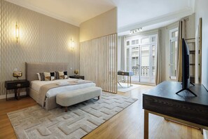 A hotel bedroom with a bed, bedside tables, a desk, and a television. - Prestige 280m² - Large Parisian apartment in the 16th arrondissement (Paris)