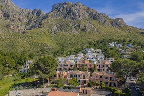 Eine Stadt an einem Hang mit Gebäuden, einer Straße und einem Berg im Hintergrund.