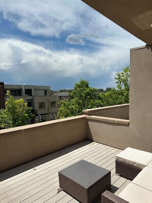 A rooftop terrace with a view of surrounding buildings and trees. - Centrally Located Urban Loft-Near Boulder and Denver (Westminster)