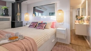 Une chambre à coucher moderne avec un lit, des tables de chevet, un miroir et une commode.