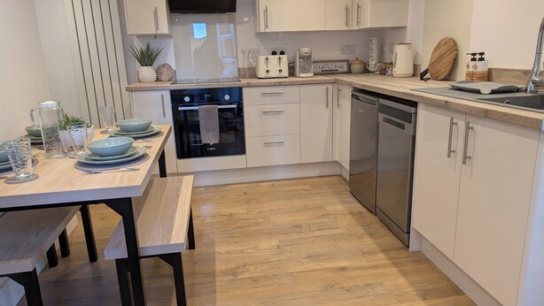 A modern kitchen with white cabinets, a Bosch oven, a dishwasher, and a coffee maker. - House in Martham (GREAT YARMOUTH)