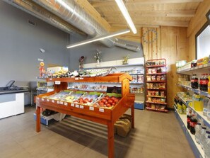 A grocery store interior with wooden shelves, a produce display, and a checkout counter. - Bungalow PMR with Terrace - Sleeps 3 (Zumaya)